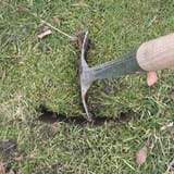 Spade pushed into the ground to make a slit